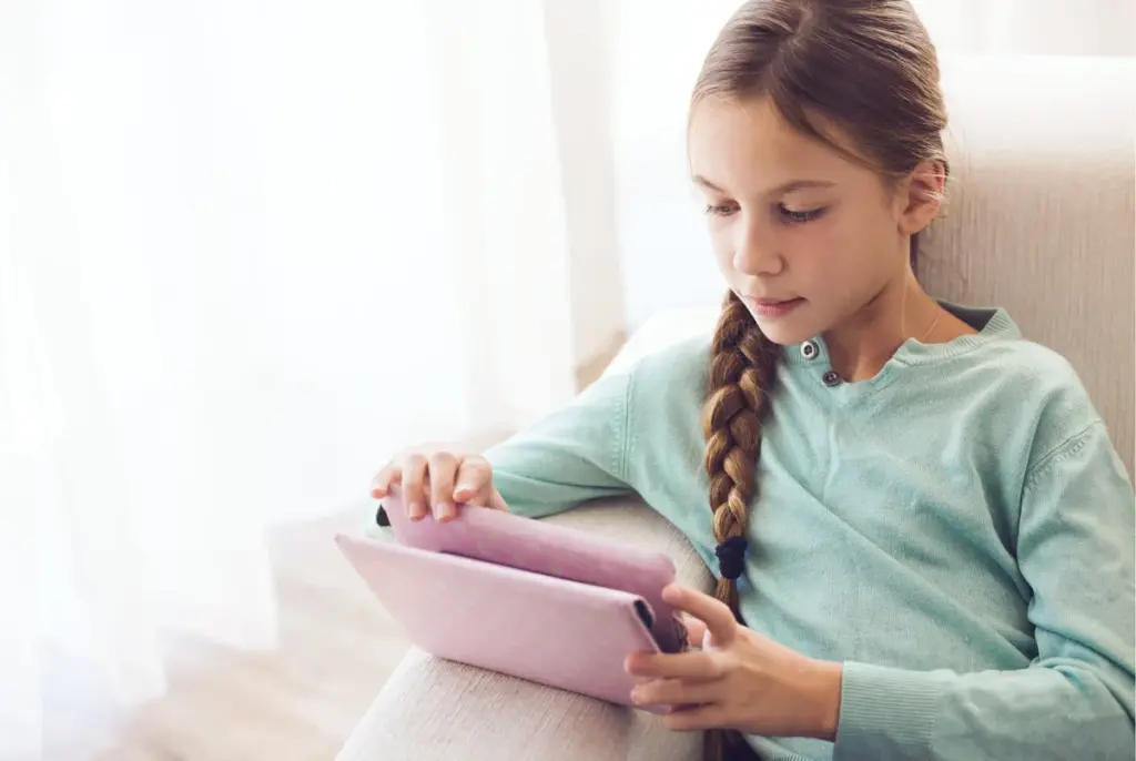 A child sitting in a chair using a tablet