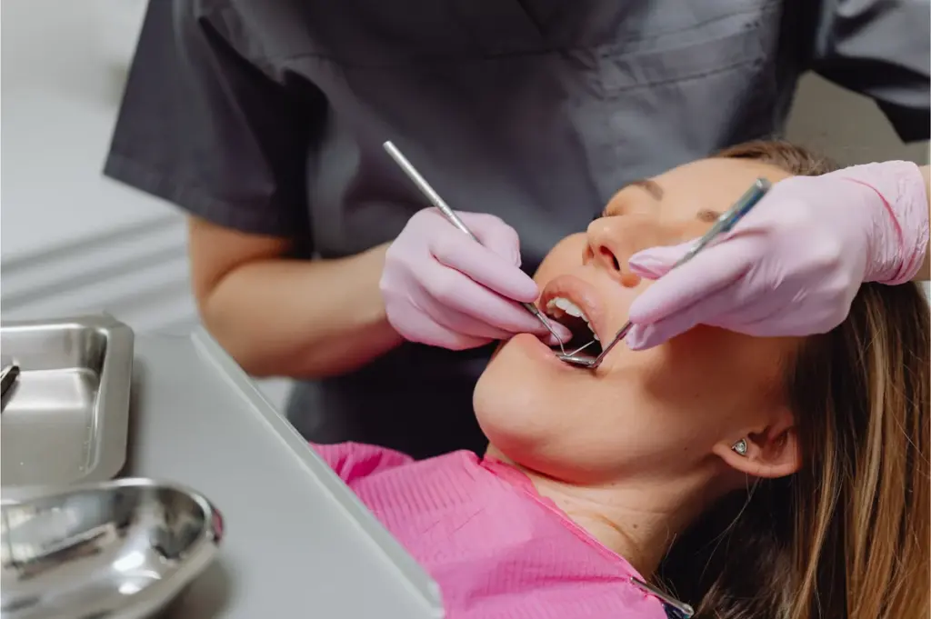 A dental hygienist cleaning a patient teeth