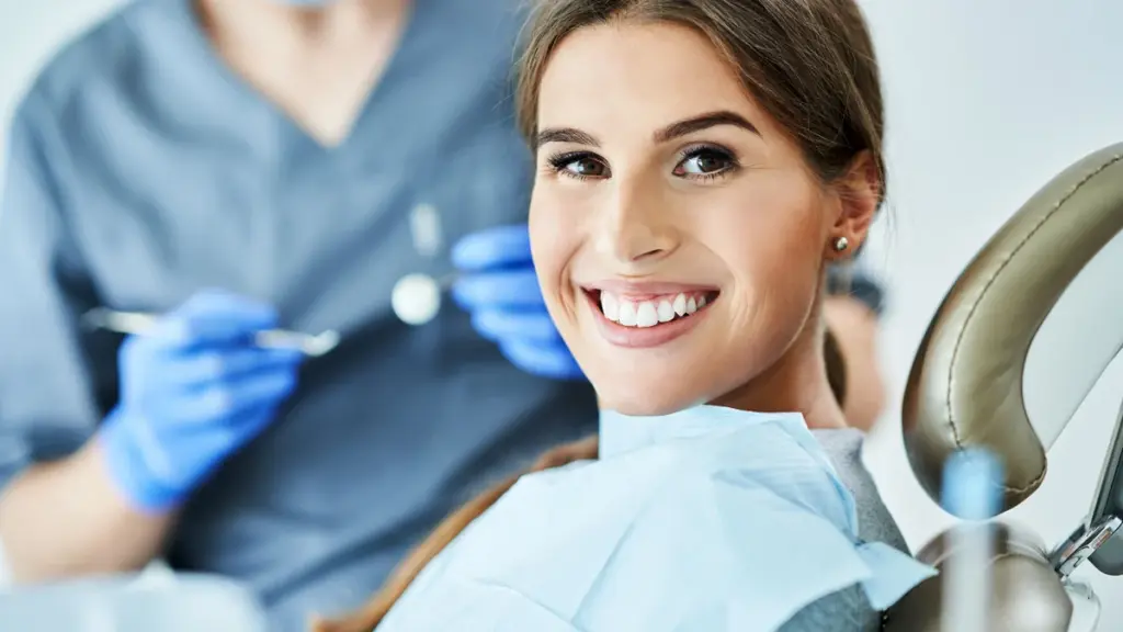 A person smiling in a dental chair during a checkup